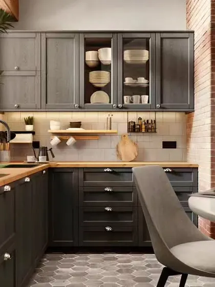 A rustic and cozy kitchen with dark grey shaker cabinets, a wood countertop, and an exposed brick accent wall.