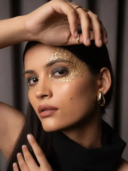 A creative beauty portrait with dramatic gold leaf makeup. This close-up shot showcases my attention to detail in makeup and lighting for striking editorial beauty work.