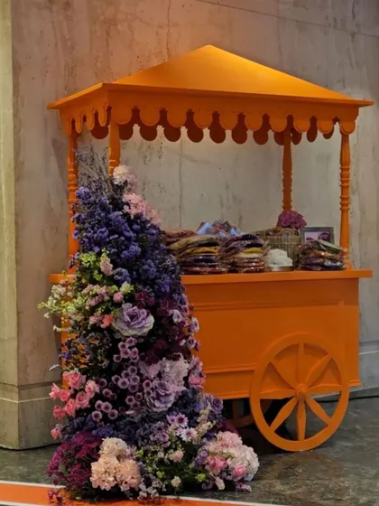 A charming, flower-adorned cart used as a favor station. We believe in incorporating whimsical and interactive elements into events to delight guests and make the celebration more memorable.