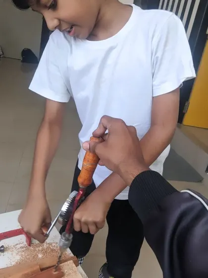 A student learns how to operate a hand drill with guidance from our instructor. It's a great confidence builder.