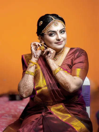 A close-up of the bride adjusting her earring, a simple gesture that makes for a beautiful, natural portrait.
