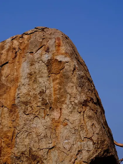 The sheer scale of the boulders in Hampi is breathtaking. Here, a climber is dwarfed by the massive granite rock, showcasing the incredible natural playground we get to explore.