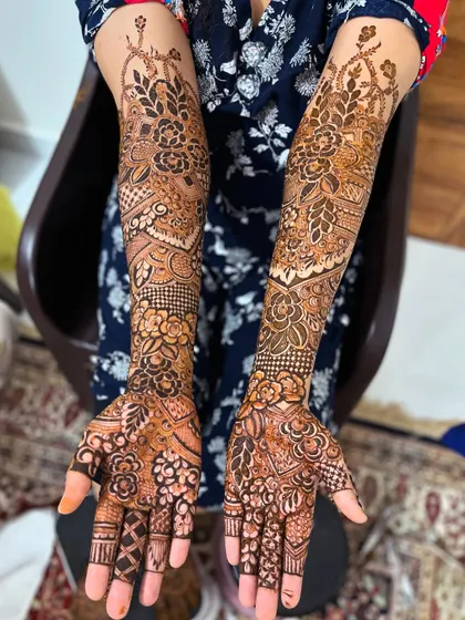 A complete view of the bridal henna on both arms, showing the beautiful symmetry and full coverage.