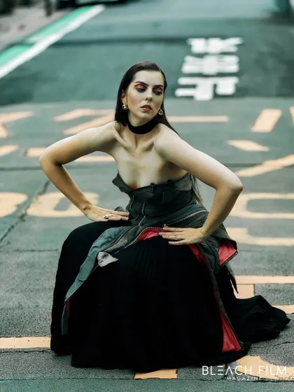 Using the street markings as a graphic element in the composition. This pose is unconventional and adds an artistic, almost abstract quality to the fashion shot.