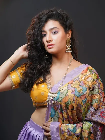 A portrait focusing on the intricate details of the printed lehenga and the traditional jewelry.