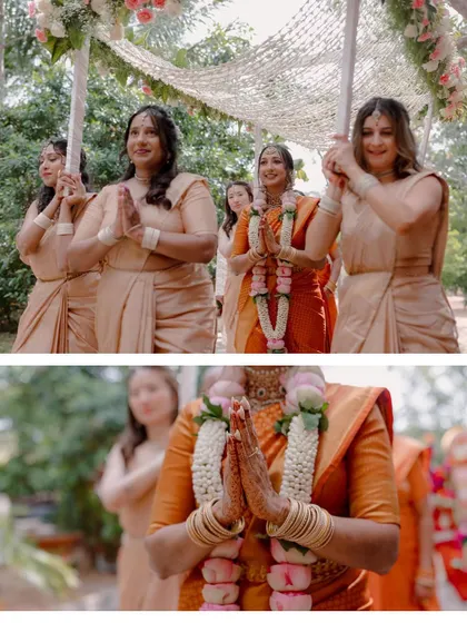 The bride's grand entrance at her South Indian wedding, escorted by her bridesmaids, with her hands joined in a respectful 'namaste'.