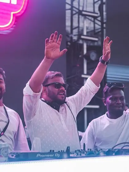 Me and the boys on stage, hands up, celebrating with the massive Holi crowd.