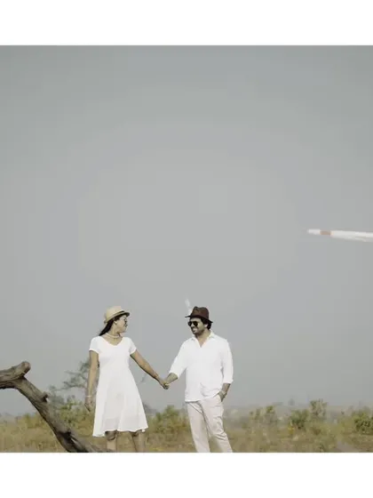 A stylish pre-wedding portrait with a vintage feel, using the unique landscape of a windmill farm.