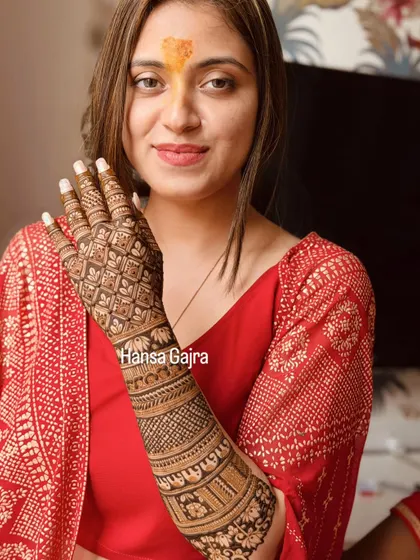 A full back-of-hand design with intricate jaali work covering the entire hand. The arm features traditional bands, creating a look of rich texture and detail.