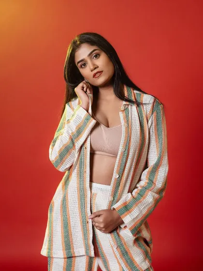 A chic and modern look for this photoshoot. The makeup is clean and fresh, with a focus on a flawless base and a soft, neutral lip, perfectly complementing the striped co-ord set.