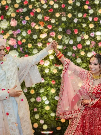 A joyful dance between the newly-garlanded couple. Their movement and smiles capture the celebratory spirit of the wedding ceremony.