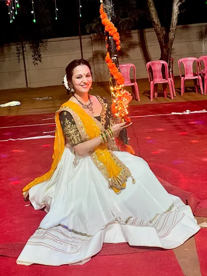 Seated on the red-carpeted floor, this photo captures the festive decor and my traditional Garba look for the evening.