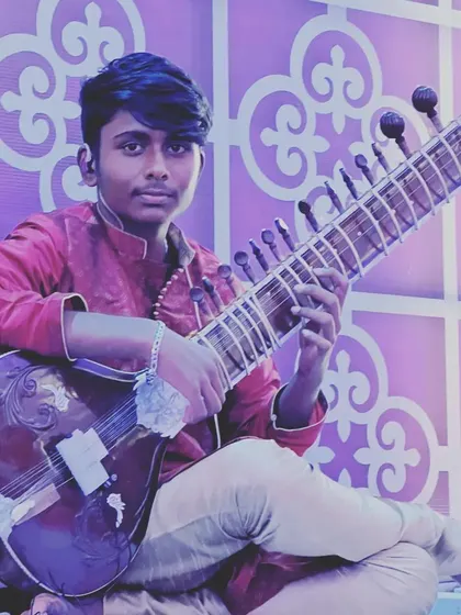 A young student, poised and ready to play. My Hindustani sitar lessons focus on correct posture and technique to build a strong foundation for complex raags.