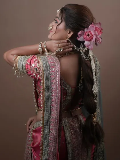 A back view showcasing the beautiful braided hairstyle adorned with a fresh lotus flower, a perfect complement to the traditional attire.