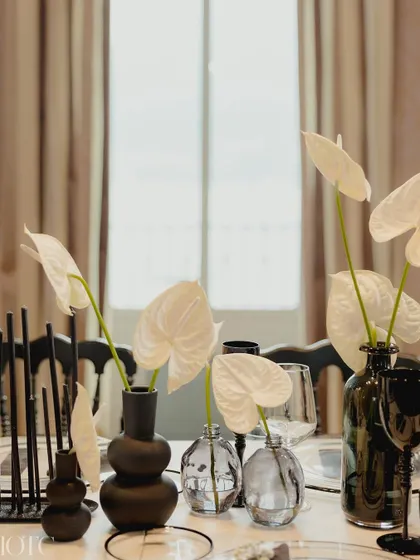 A close-up of the black and white tablescape, featuring white anthuriums in modern black vases.