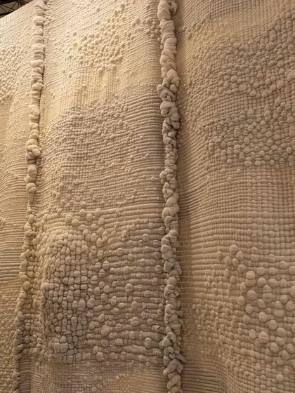 A close-up of the textured, hand-stitched fabrics from 'Sleep Sense'. The piece is an evocative and metaphorical space that alludes to a pure, stress-free state of rest.