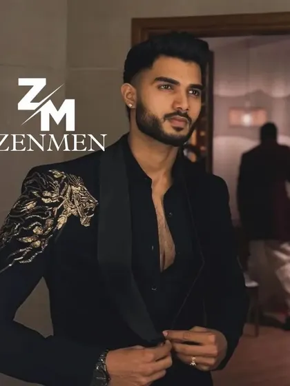A model getting ready in a black tuxedo with a powerful gold lion embroidered on the shoulder. This is a prime example of creating a personalized, statement piece.