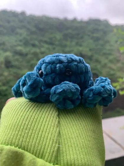 A side view of the velvet octopus amigurumi, showing off its curly tentacles. These plushies are great sensory toys or just cute desk buddies.