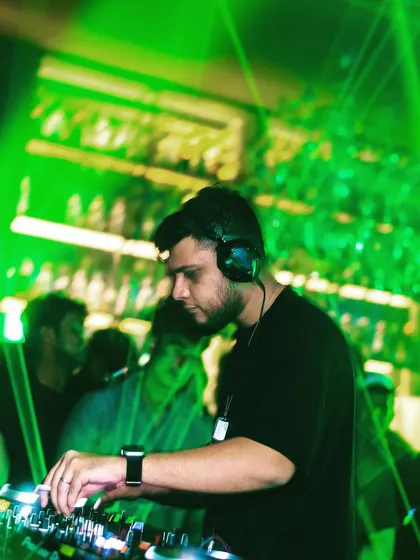 Mixing under a web of green lasers. The visual production is just as important as the music for creating an immersive experience.