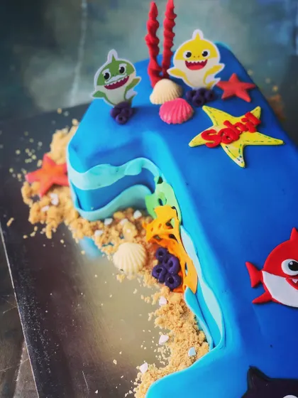 Our Baby Shark first-birthday cake appears here in a still view, with underwater decorations and the character theme.