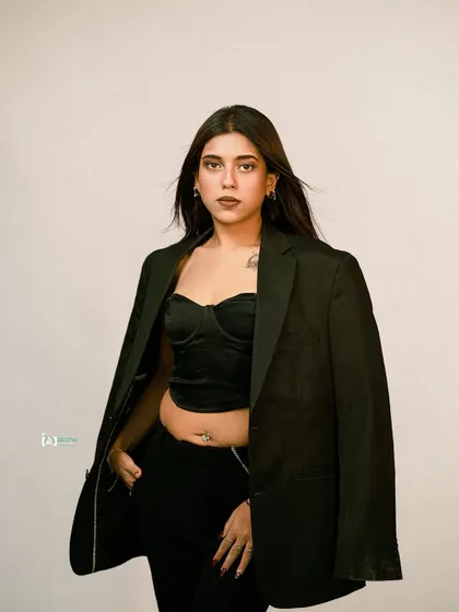 A modern, edgy look with a black corset and blazer. This studio shot is all about attitude, conveying strength and style for a contemporary fashion portfolio.
