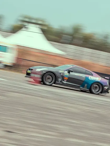 The GTR captured in a dynamic, angled shot, conveying a sense of immense speed and power as it hurtles down the track.