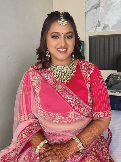 The complete look is one of timeless Indian beauty. The makeup enhances her features, while the soft curls in her hair add a touch of modern romance.