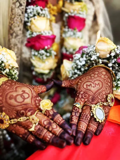 The perfect engagement shot. The mehndi features the couple's initials 'MM' in a heart and a drawing of their rings.