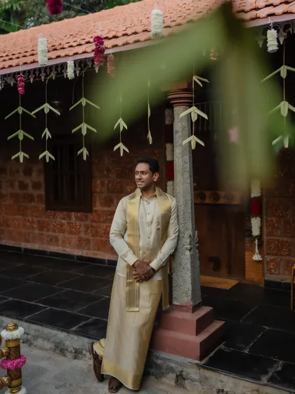 A classic portrait of the groom in his traditional wedding attire, set against the charming backdrop of a heritage venue.