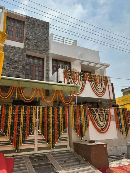We decorate the entire home to announce the wedding festivities. This house exterior is adorned with beautiful garlands of orange and yellow marigolds for a traditional and welcoming look.