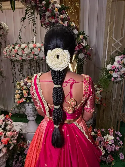 The elegance of this segmented braid lies in its simplicity and clean execution. The jasmine veni provides a beautiful contrast against the dark hair and colorful outfit.