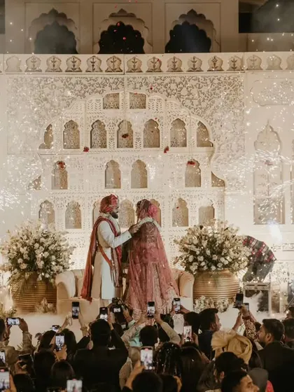 Another angle of the grand, palace-style varmala, showing the scale of the event and the many guests capturing the moment.