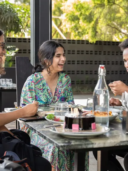 A group of friends laughing and enjoying a meal together. This is what Sundays are for.