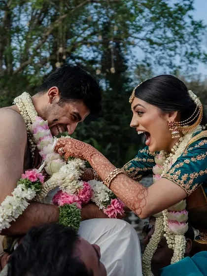 The sheer fun of a South Indian wedding ritual. This candid shot captures the competitive spirit and laughter as the couple playfully vies for the upper hand.