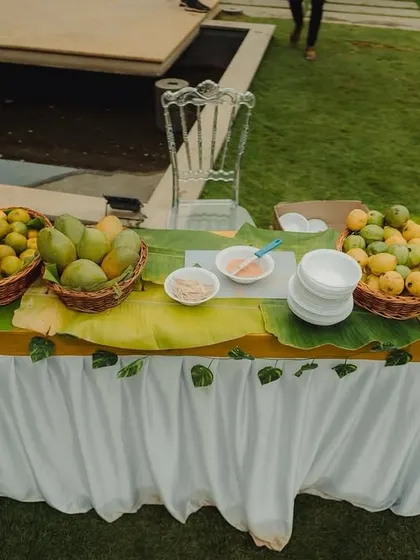 A fresh fruit station with baskets of mangoes and lemons, offering a refreshing and healthy treat for guests.