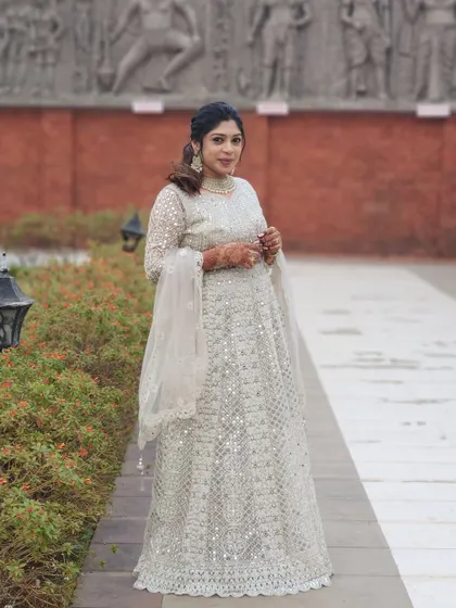 A full-length shot of the guest's elegant white outfit and polished makeup look.