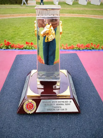 The P.V. Shetty Memorial Cup, a crystal trophy with a golden horse head inside.