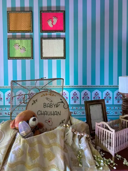 A sweet and personalized corner for 'Baby Chauhan', featuring a custom embroidery hoop, a teddy bear, and a miniature cradle.