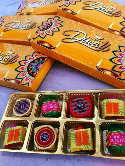 A festive box of Diwali-themed chocolates designed to look like firecrackers such as 'Sutli Bomb' and 'Chakri'. These are always a hit for corporate Diwali gifting.