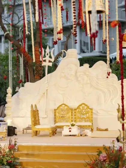 The wedding stage, with its custom Shiva and Parvati sculpture, is framed by trees adorned with hanging floral strings and temple bells. Every detail was curated to enhance the divine and timeless theme of the ceremony.