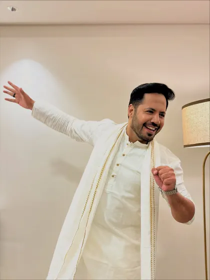 A fun, dancing pose in the all-white outfit. It shows that even an elegant look can be full of life and movement.