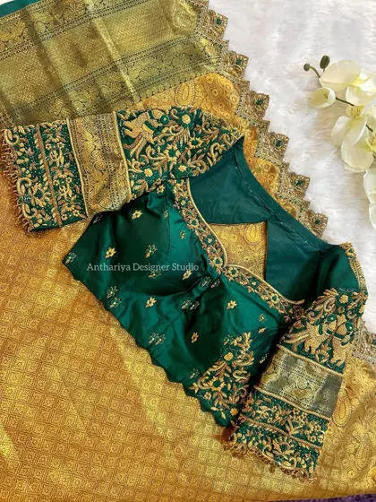 A majestic bottle green blouse with heavy gold embroidery, perfectly complementing a gold Kanjivaram saree.