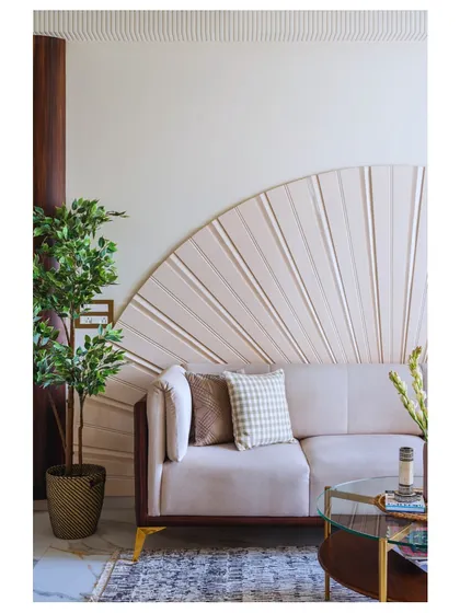 The living room of 'Apartment 601' is all about warm tones and lush greenery. The fan-like detail behind the sofa adds a unique, sculptural element to the space.