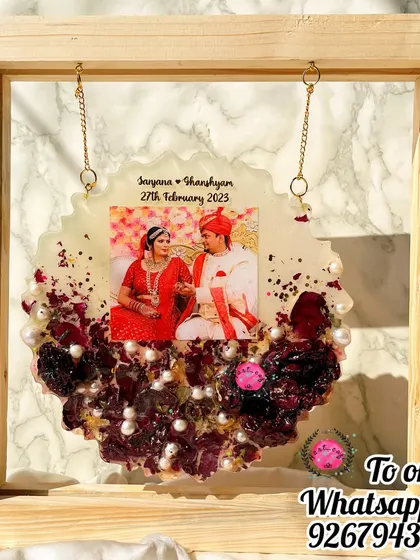 This hanging decorative plaque is a beautiful way to display your wedding memories. The preserved flower piece hangs within a wooden frame, creating a lovely shadow box effect.
