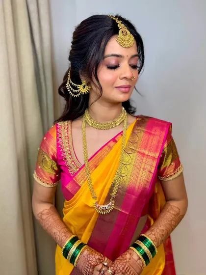 With her eyes closed, you can truly appreciate the artistry of the eyeshadow blending. This look is soft, romantic, and perfectly complements her traditional yellow and pink silk saree.