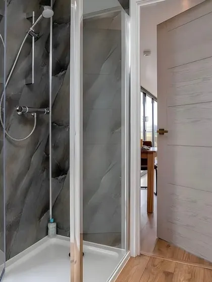 I like to use interesting textures in my designs. This bathroom in a container home features a striking, slate-textured shower wall that adds a touch of rustic modernity.