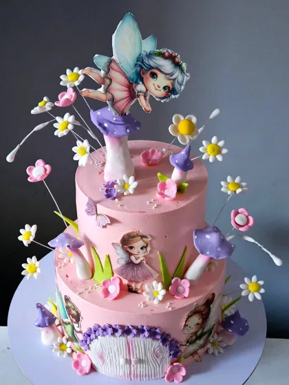 The full view of the two-tiered pink fairy cake, showing how all the elements come together to create a vibrant and magical fairyland scene.
