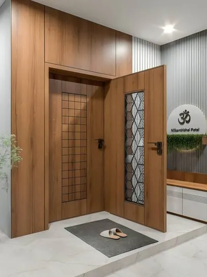 This welcoming entrance features a beautiful wooden door with glass panels and a cozy bench next to a nameplate with the Om symbol. It perfectly blends modern design with a touch of tradition.