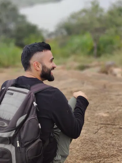 A trekker taking a well deserved break, smiling as he looks out over the landscape. These are the peaceful, rewarding moments.
