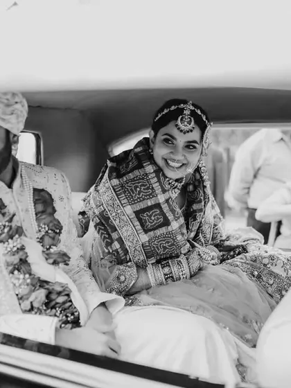 A classic black and white shot of the couple sharing a happy moment in their wedding car after the ceremony.